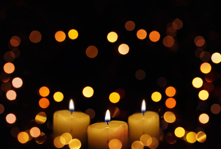 Candles glowing with defocused lights. Christmas and New Year Bokeh background.の写真素材