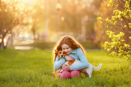 Little girl hugging her friend a dog in outdoors. Friendship, animal protection, lifestyle concept.の写真素材