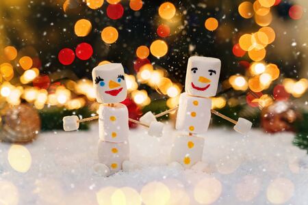 Marshmallow snowmen holding hands. Holiday concept. Christmas background with sweets.の写真素材