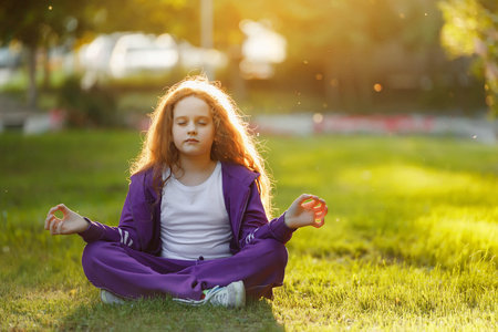 Cute girl meditation in summer park. Healthy, lifestyle concept.