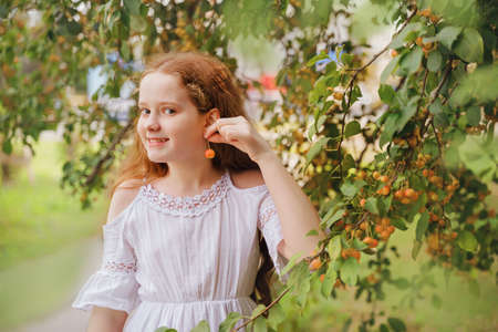 Cute girl holding a branch of a fruit tree. Protection, ecology, healthy concept.の写真素材