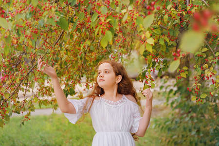 Cute girl holding a branch of a fruit tree. Protection, ecology, healthy concept.の写真素材