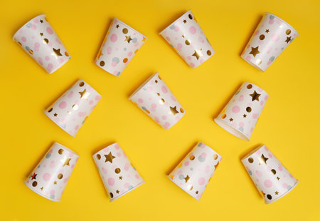 Paper cups on yellow background. Pattern with high top view.の写真素材