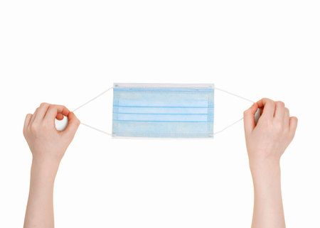 Child hands holding medical mask. High top view isolated on white background. Protection, healthy,  concept.の写真素材