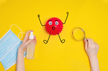 Child hands are holding an antiseptic spray, a medical mask and a magnifying glass to kill the  bacteria. Healthy, medical concept.の写真素材