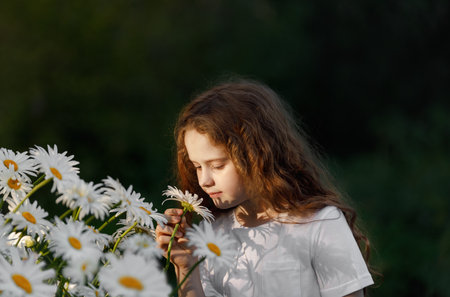 Cute girl shelling daisy flower. Healthy, medical concept.の写真素材