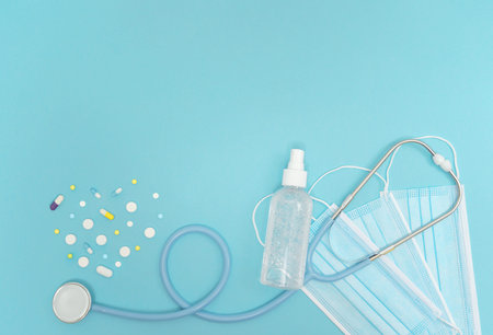 High top view background with stethoscope, antiseptic spray and pills. Medicine equipment for...