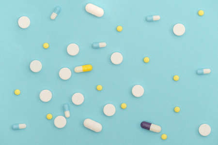 Medicine capsules, pills and tablets on light blue background. Pharmaceutical, medical, health care concept.の写真素材