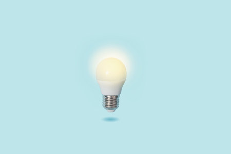 Glowing light LED bulb with copy space, top view. Business, idea, education concept.