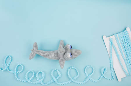 Handmade crochet shark on a blue background.の写真素材