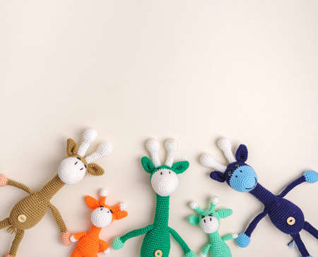 Family of giraffes handmade knitted crochet on a beige background.の写真素材