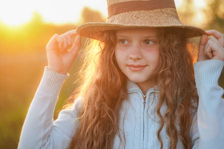 Curly girl in straw hat enjoy warm summer day.の写真素材