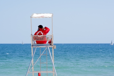 Lyfeguard sitting in the surveillance tower, watching the sea  のeditorial素材