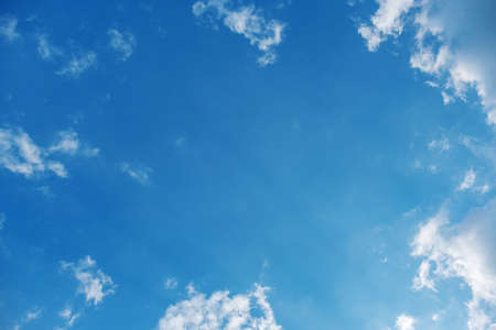 photo of several clouds on a blue sky background arranged like a frame, space for copyの写真素材