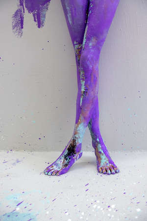 beautiful sexy legs and feet on tiptoe of a young artistically abstract painted woman, ballerina with white, blue and purple paint. Creative body art painting, copy spaceの写真素材