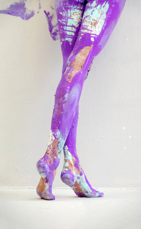 View from behind on beautiful legs and feet of a sexy young artistically abstract painted woman,...