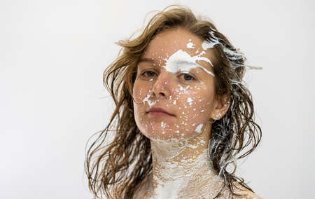 Portrait of a sexy brunette self-confident proud woman painted with white color spots and color splashes on her face, creative expressive abstract body painting art, copy spaceの写真素材