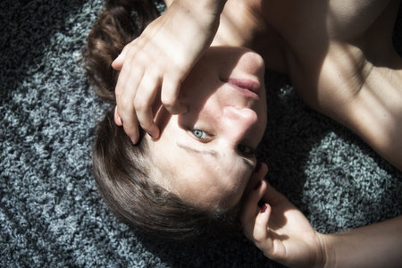 Portrait of a beautiful young attractive sexy woman, lying on carpet, partially with decorative...