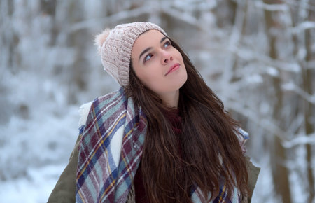 Beautiful young girl portrait with scarf, hat. Beauty joyful model cold in winter park. Happy...