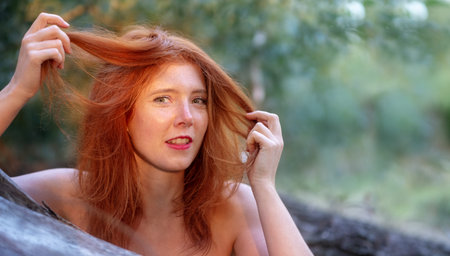 beautiful young sexy red-haired girl enjoys smiling happily playing at her beautiful gorgeous red...