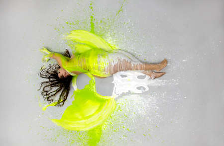 plus size, fat, overweight, chubby, expressive sexy woman lies naked elegantly on the floor in green, white color, rolls to the side, spreads the paint in the form of angel wings, copy spaceの写真素材