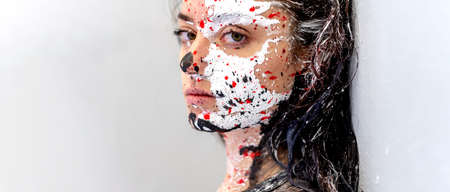 Seductive portrait of a sexy young proud and stern, strict looking brunette woman, dots of white, black and red color paint, decorative, creative expressive abstract painting art, make up, copy spaceの写真素材