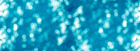 wide banner panorama turquoise bokeh background. Abstract Light Circles, abstract blue sea christmas background with blur light effect, out of focus, copy spaceの写真素材