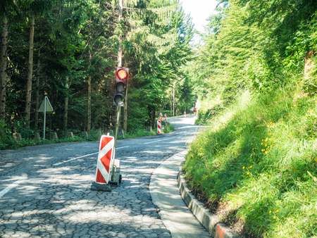 red signal at a construction site on a small road in the alpsの写真素材