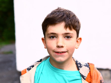 preteen handsome boy outdoor portrait on the white wall background