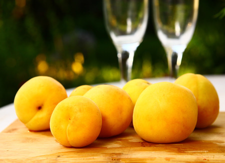 full ripe apricots outdoor with wine glassesの写真素材