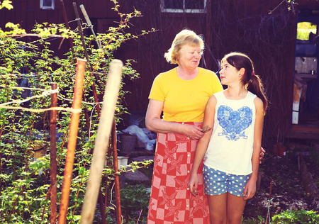 teenager girl and her grandma in the country spring gardenの写真素材