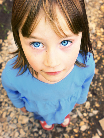beautiful blond girl with blue eyes foreshorteing outdoor summer portraitの写真素材
