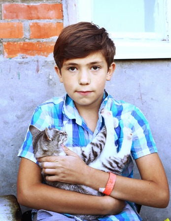 preteen  handsome country boy with kitten close up portraitの写真素材