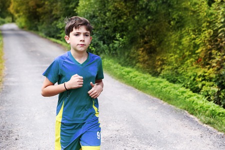 teenager   boy in sportswear run on the country roadの写真素材