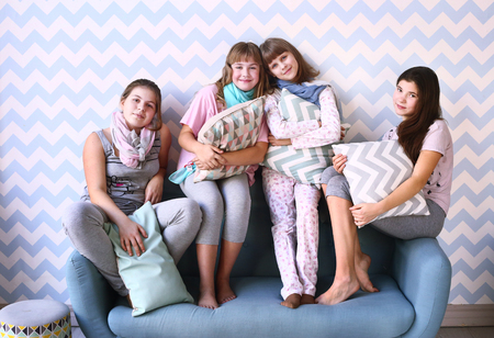 teen four girls on pajama party with pillowsの写真素材