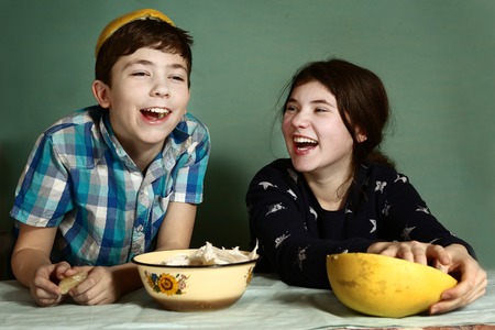 creative kids teenage siblings brother and sister laughing peeling grape fruit make funny hat from itの写真素材