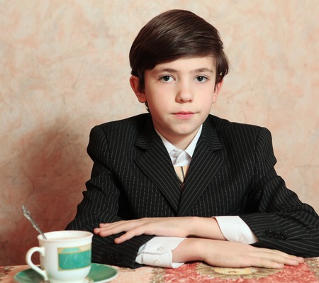 businessman boy in black suit coffee sit at the table close up portraitの写真素材