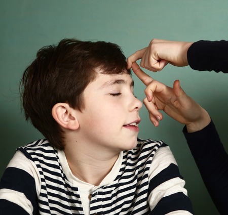 boy got fillip flick on his forehead because of lost bet wagerの写真素材