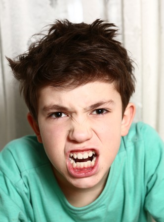 preteen boy in anger rage emotional closeup portraitの写真素材