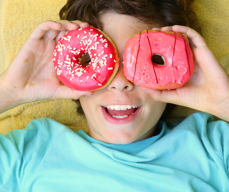 preteen boy with doughnut glasses close up portrait smiling laughingの写真素材