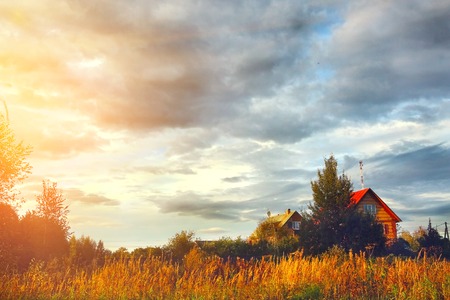 village house on field and cloudy sky autumn backgroundの写真素材