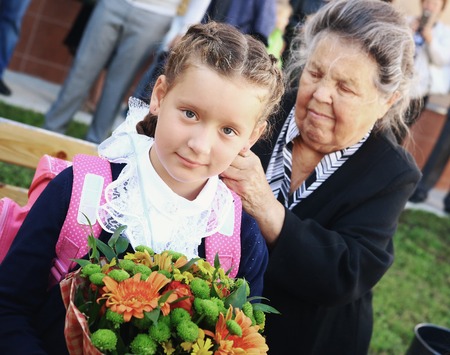 Moscow, Russia - September 1, 2016: Unidentified girls with flowers bouquet on solemn meeting of first grade kids, called the Day of Knowledge, signify the beginning of school year.のeditorial素材