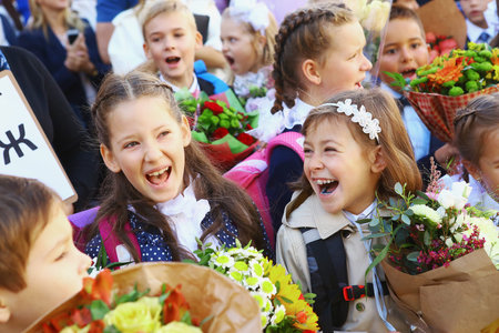 Moscow, Russia - September 1, 2016: Unidentified girls with flowers bouquet on solemn meeting of first grade kids, called the Day of Knowledge, signify the beginning of school year.のeditorial素材