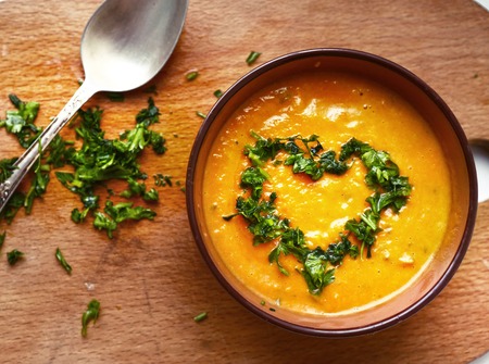 smashed pumpkin soup close up photo with parsley heart and spoonの写真素材