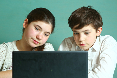 teenager siblings girl boy with laptop studying online lessonの写真素材