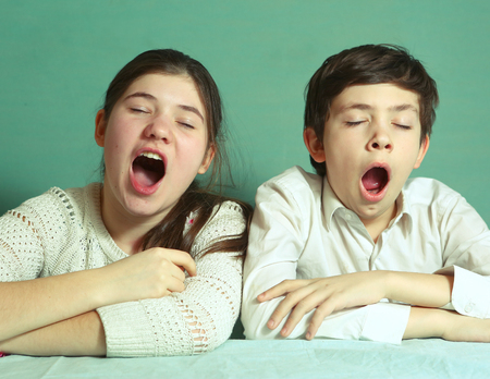 teen siblings brother and sister yawning close up portraitの写真素材