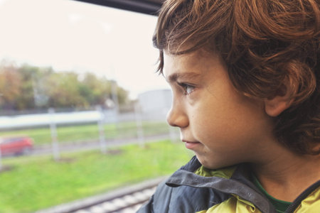 preteen boy in train look at window close up photo