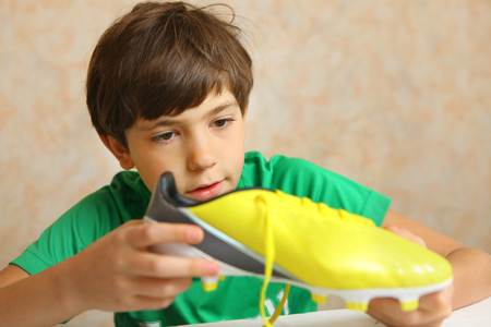 brand new yellow soccer boots . Boy with new soccer bootsの写真素材