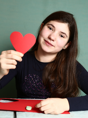 pretty girl with valentines day red heart close up portraitの写真素材