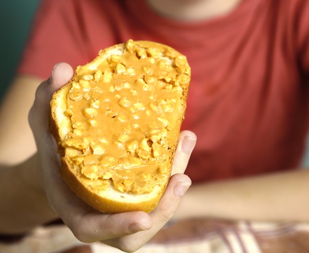 peanut butter with nut peaces spread on bread slice, peanut butter sandwichの写真素材